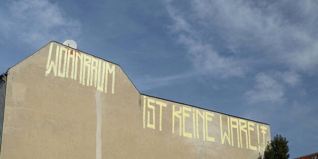 Eine Brandwand eines Hauses, darauf ein Graffiti: „Wohnraum ist keine Ware“ Eine Brandwand eines Hauses, darauf ein Graffiti: „Wohnraum ist keine Ware“
