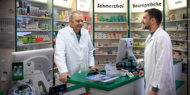 Zwei Männer stehen in einer Apotheke