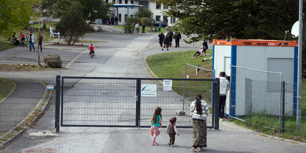 Eine Frau und zwei Kinder vor dem Tor der Flüchtlingsunterkunft Burbach Eine Frau und zwei Kinder vor dem Tor der Flüchtlingsunterkunft Burbach