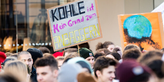 Jugendliche auf einer Demo, jemand hält ein Schild mit der Aufschrift "Kohle ist kein Grund zum Anbaggern" Jugendliche auf einer Demo, jemand hält ein Schild mit der Aufschrift "Kohle ist kein Grund zum Anbaggern"