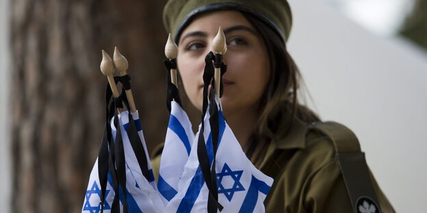 eine soldatin vor israelischen Flaggen eine soldatin vor israelischen Flaggen
