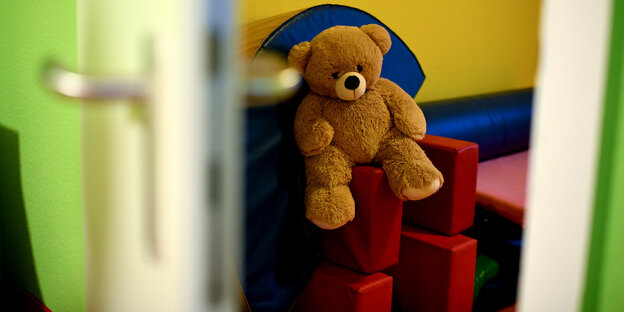 Ein Stoffteddy sitzt im Kinderbereich eines Frauenhauses Ein Stoffteddy sitzt im Kinderbereich eines Frauenhauses