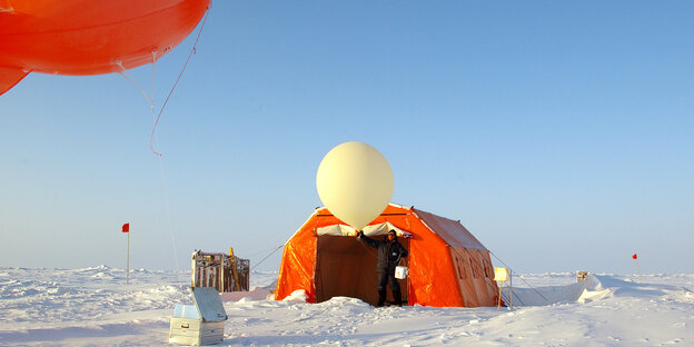 Ein Forscher lässt ein Wetterballon steigen Ein Forscher lässt ein Wetterballon steigen