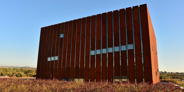 Das Museum: ein massiver, rostroter, quadratischer Monolith, mitten in der Landschaft