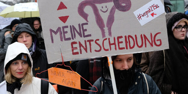 Frauen protestieren mit einem Schild Frauen protestieren mit einem Schild