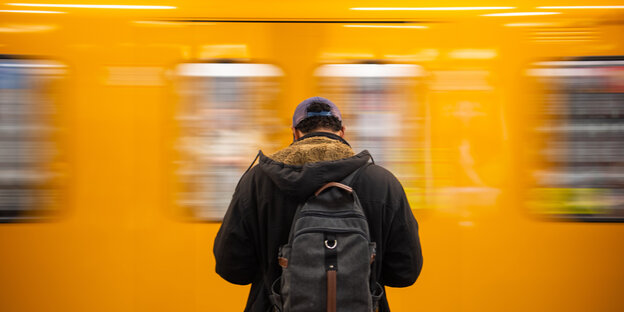 Ein Mann steht vor einer fahrenden U-Bahn Ein Mann steht vor einer fahrenden U-Bahn