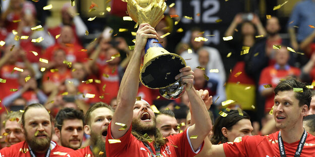 Handballer Hansen reckt goldene Trophäe in die Höhe Handballer Hansen reckt goldene Trophäe in die Höhe