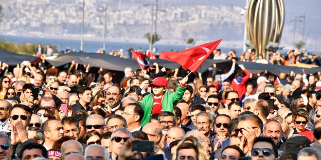 Menschen versammeln sich mit der türkischen Fahne am Meer Menschen versammeln sich mit der türkischen Fahne am Meer