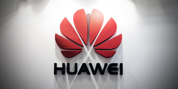 Firmenlogo von Huawei an einer beleuchteten Wand Firmenlogo von Huawei an einer beleuchteten Wand