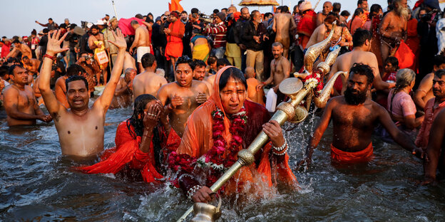 mehrere Menschen in orangefarbener Kleidung im Wasser mehrere Menschen in orangefarbener Kleidung im Wasser