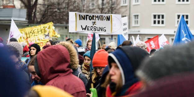 Ein Schild auf einer Demonstration, auf ihm steht: Informationen sind nicht gleich Werbung Ein Schild auf einer Demonstration, auf ihm steht: Informationen sind nicht gleich Werbung