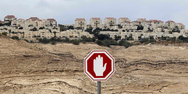 Ein Stoppschild in der West Bank, im Hintergrund mehrere Wohnhäuser Ein Stoppschild in der West Bank, im Hintergrund mehrere Wohnhäuser