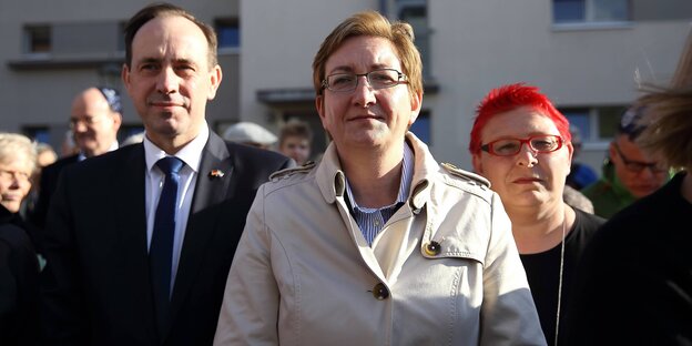 Zwei Frauen und ein Mann stehen versetzt nebeneinander Zwei Frauen und ein Mann stehen versetzt nebeneinander