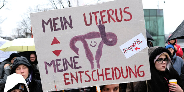 Eine Teilnehmerin einer Demonstration gegen die Paragrafen 218 und 219a, die Schwangerschaftsabbrüche und das Werbeverbot dafür regeln, hält ein Schild mit der Aufschrift "Mein Uterus, meine Entscheidung" hoch Eine Teilnehmerin einer Demonstration gegen die Paragrafen 218 und 219a, die Schwangerschaftsabbrüche und das Werbeverbot dafür regeln, hält ein Schild mit der Aufschrift "Mein Uterus, meine Entscheidung" hoch