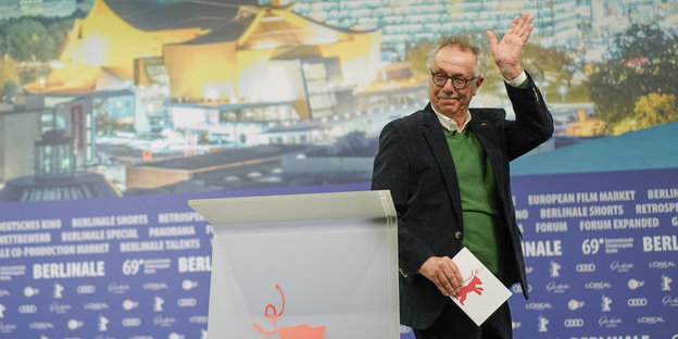 ein Mann verlässt eine Bühne und winkt dabei ein Mann verlässt eine Bühne und winkt dabei