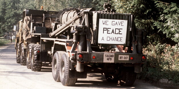 eine Rakete auf einem Armeelaster, hinten dran hängt ein Schild, auf dem „We gave peace a chance“ steht eine Rakete auf einem Armeelaster, hinten dran hängt ein Schild, auf dem „We gave peace a chance“ steht