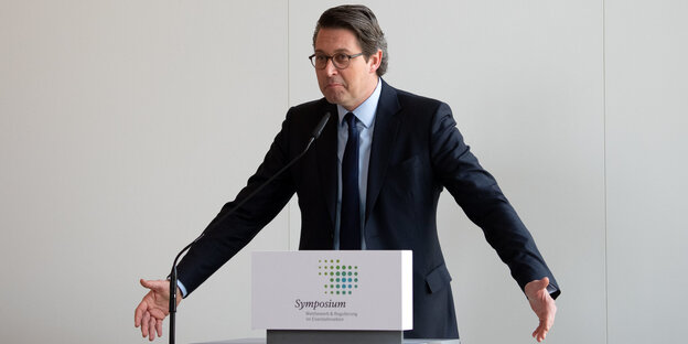 Andreas Scheuer, ein Mann in Anzug und mit Brille steht an einem Redepult und zuckt mit den Schultern Andreas Scheuer, ein Mann in Anzug und mit Brille steht an einem Redepult und zuckt mit den Schultern
