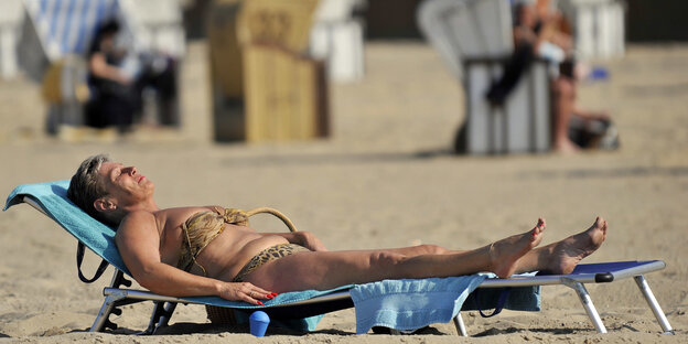 Ältere Frau im Bikini auf einer Strandliege Ältere Frau im Bikini auf einer Strandliege