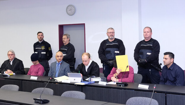 Angeklagte, Übersetzer, Anwälte und Justizbeamte in einem Gerichtssaal Angeklagte, Übersetzer, Anwälte und Justizbeamte in einem Gerichtssaal