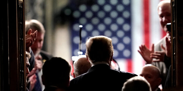 Trump von hinten vor US-Flagge Trump von hinten vor US-Flagge