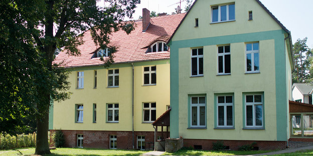 ein gelb angestrichenes Haus mit Seitenflügel