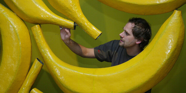 Ein Arbeiter und Plastikbananen Ein Arbeiter und Plastikbananen