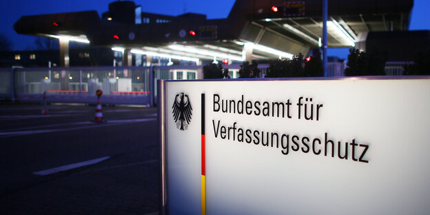Auf einem Schild steht Bundesamt für Verfassungsschutz, dahinter ist ein Gebäude zu erkennen Auf einem Schild steht Bundesamt für Verfassungsschutz, dahinter ist ein Gebäude zu erkennen