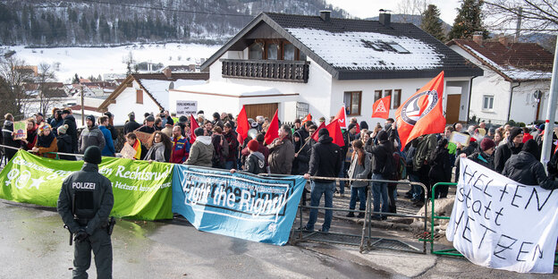 In Burladingen steht eine Menschenmenge mit Transparenten hinter einer Absperrung In Burladingen steht eine Menschenmenge mit Transparenten hinter einer Absperrung