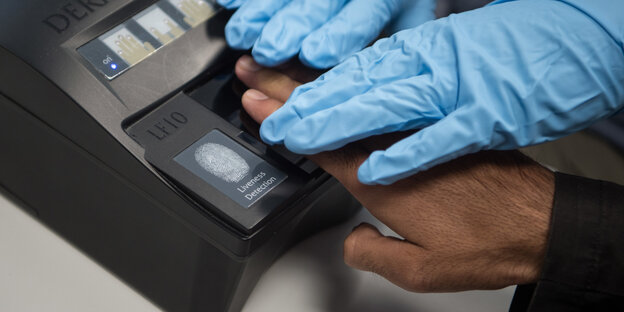 Hand wird auf Lesegerät für Fingerabdruck gelegt Hand wird auf Lesegerät für Fingerabdruck gelegt