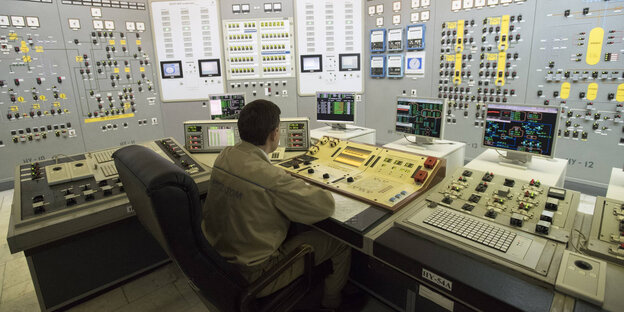 Ein Mann sitzt im Schaltraum eines AKW Ein Mann sitzt im Schaltraum eines AKW