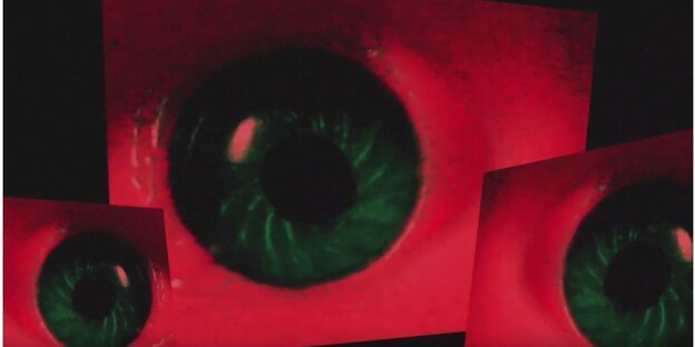 Drei grüne Augen auf rotem Hintergrund Drei grüne Augen auf rotem Hintergrund