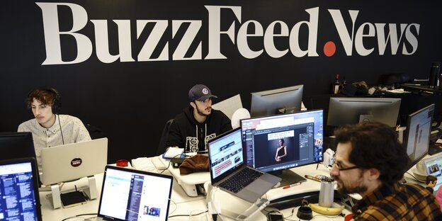 In einem Raum stehen zahreiche Computer, an denen Menschen arbeiten. An der Wand ist der große Schriftzug "BuzzFeed.News" zu lesen In einem Raum stehen zahreiche Computer, an denen Menschen arbeiten. An der Wand ist der große Schriftzug "BuzzFeed.News" zu lesen