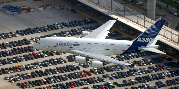 Ein Flugzeug startet, unter ihm sieht man viele Autos