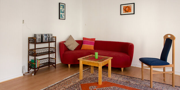 Ein Zimmer mit Sofa, Regal, Tisch und Stuhl. Ein Zimmer mit Sofa, Regal, Tisch und Stuhl.