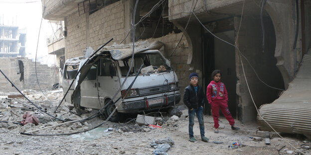 Zwei Kinder im syrischen Ost-Ghuta vor völlig zerstörten Häusern Zwei Kinder im syrischen Ost-Ghuta vor völlig zerstörten Häusern