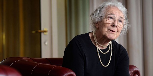 Die Kunderbuchautorin Judith Kerr sitzt auf einem roten Ledersofa Die Kunderbuchautorin Judith Kerr sitzt auf einem roten Ledersofa