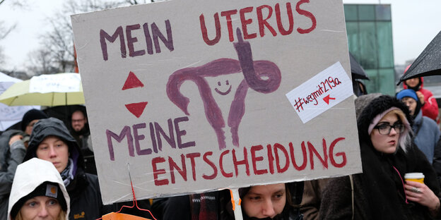 frauen demonstrieren mit schild gegen demonstration gegen paragrafen 218 und 219a