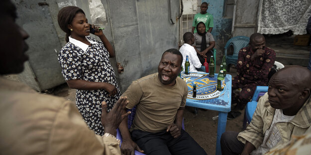 Nigerianer diskutieren beim Biertrinken Nigerianer diskutieren beim Biertrinken