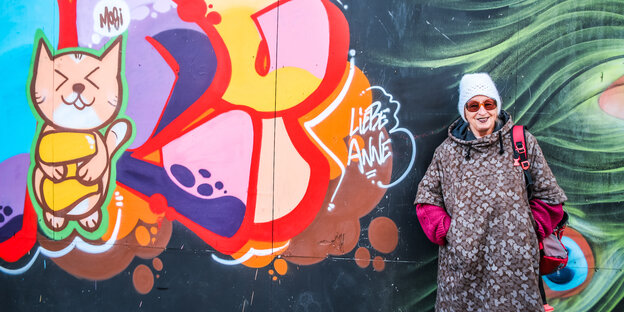 Anne Schmeckies steht vor einer mit Graffiti besprühten Wand. Anne Schmeckies steht vor einer mit Graffiti besprühten Wand.