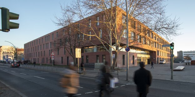 ein großes, modern aussehendes Schulgebäude an einer mehrspurigen Straße ein großes, modern aussehendes Schulgebäude an einer mehrspurigen Straße