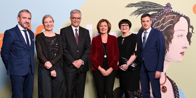 Männer und Frauen stehen vor einer Wand Männer und Frauen stehen vor einer Wand