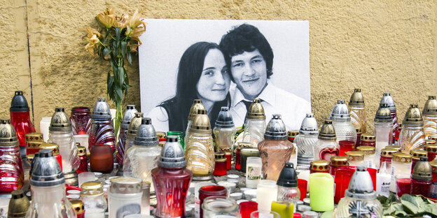 Viele Kerzen und ein schwart-weißes Foto von einer Frau und einem Mann Viele Kerzen und ein schwart-weißes Foto von einer Frau und einem Mann