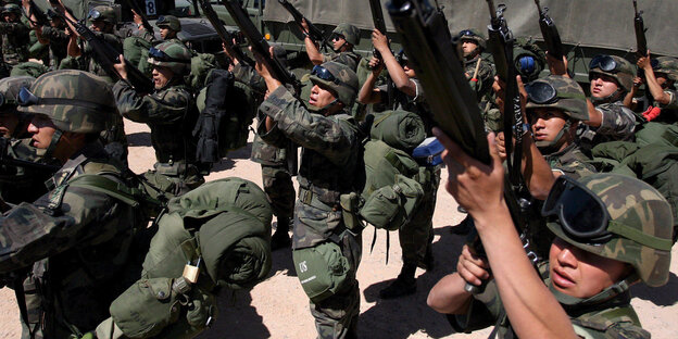 mexikanische uniformierte soldaten bereiten sich für einen einsatz vor und halten ihre sturmgewehre hoch mexikanische uniformierte soldaten bereiten sich für einen einsatz vor und halten ihre sturmgewehre hoch