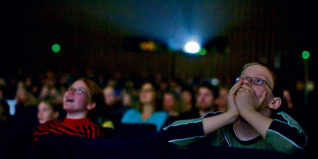 Schüler sitzen im Kino und schauen auf die Leinwand. Schüler sitzen im Kino und schauen auf die Leinwand.