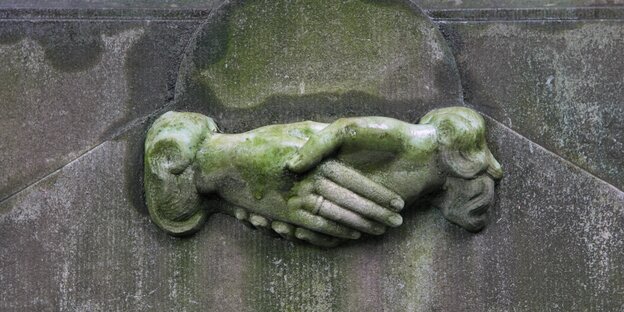 Grabstein-Relief zeigt in einander gelegte Hände Grabstein-Relief zeigt in einander gelegte Hände
