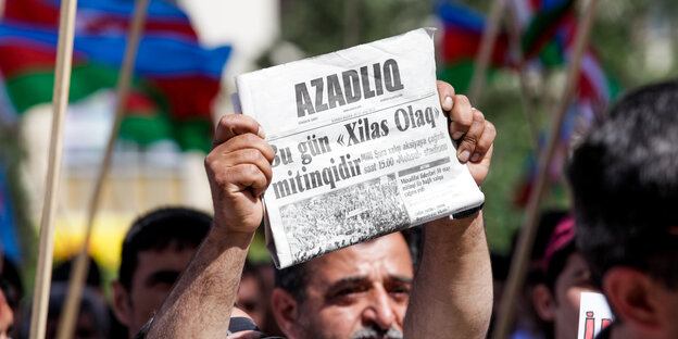Ein Mann hält ein Exemplar der Zeitung Azadliq hoch. Demonstration für Pressefeiheit 2015 in Baku Ein Mann hält ein Exemplar der Zeitung Azadliq hoch. Demonstration für Pressefeiheit 2015 in Baku