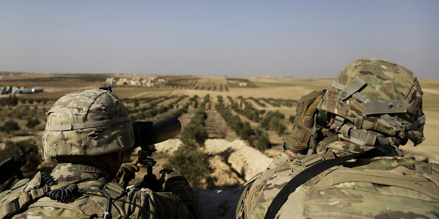 07.02.2018, Syrien, Manbij: Zwei US-Soldaten schauen von ihrer Basis in Syrien zur türkischen Grenze hinüber. 07.02.2018, Syrien, Manbij: Zwei US-Soldaten schauen von ihrer Basis in Syrien zur türkischen Grenze hinüber.