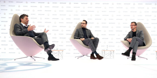 Drei Männer in grauen Anzügen sitzen in futuristischen Sesseln vor einem weißen Hintergrund Drei Männer in grauen Anzügen sitzen in futuristischen Sesseln vor einem weißen Hintergrund