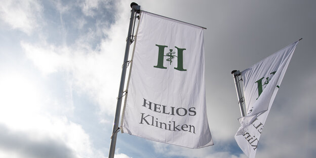 Zwei Fahnen mit Helios-Logo flattern im Wind. Zwei Fahnen mit Helios-Logo flattern im Wind.