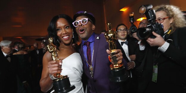 Zwei Personen halten Oscars in den Händen und freuen sich Zwei Personen halten Oscars in den Händen und freuen sich